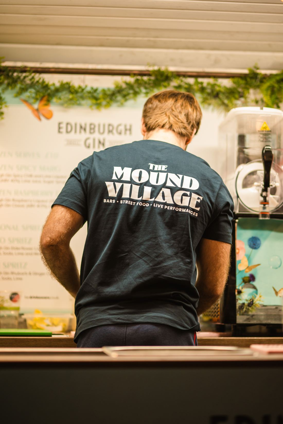 Apex team member in a Mound Village t-shirt behind the bar