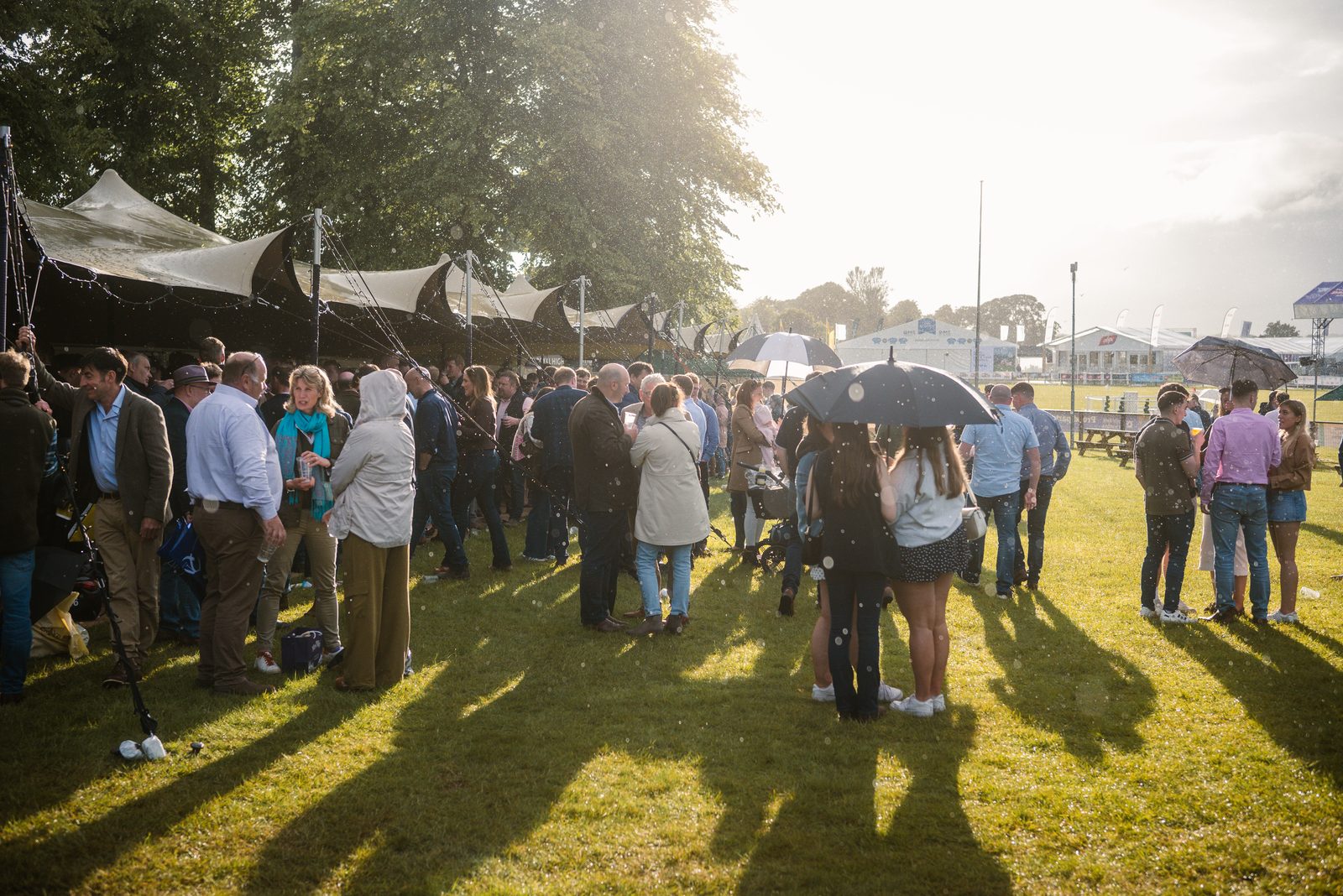 Crowd on the lawn at sunset outside the bar
